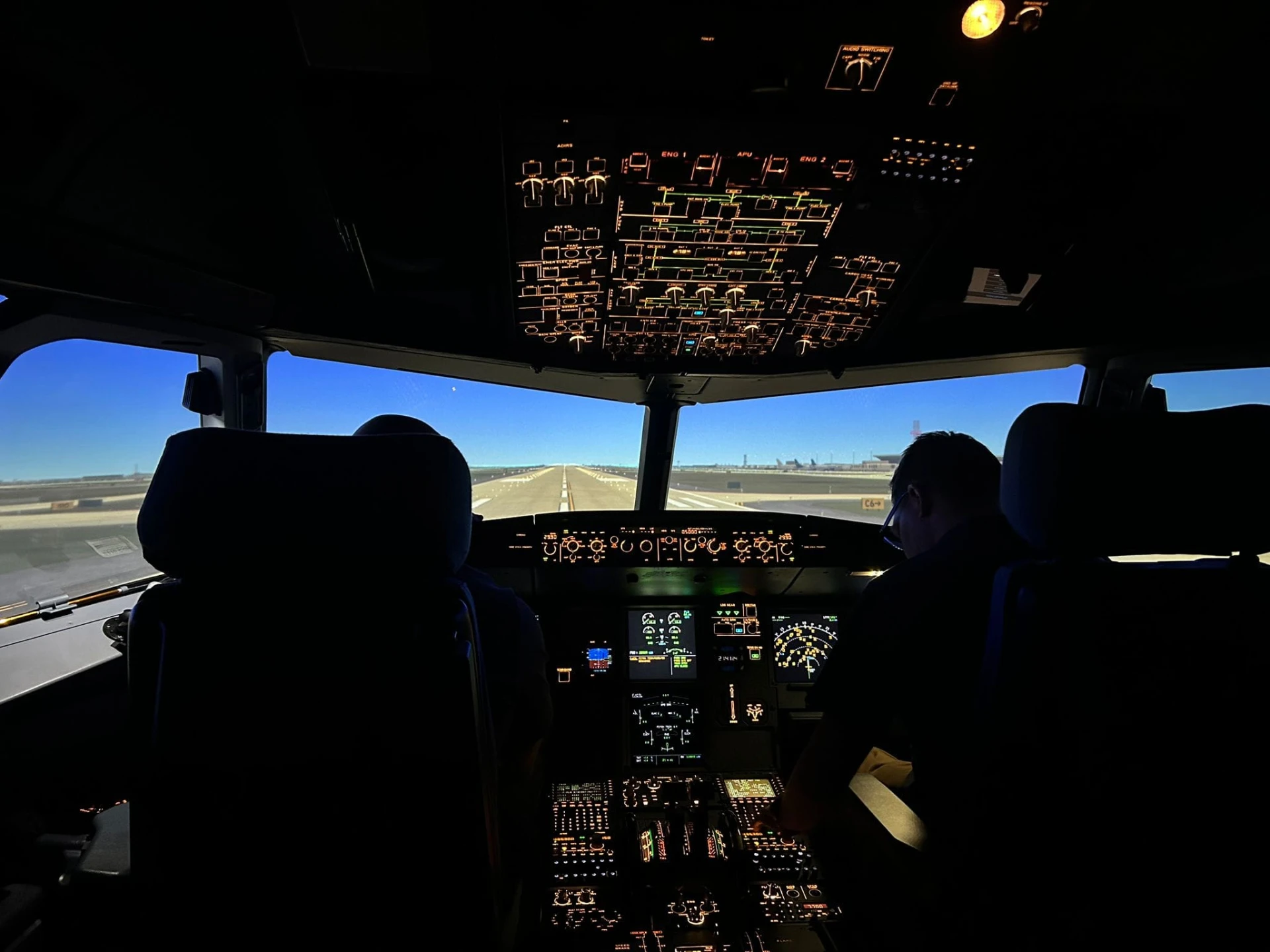 Guests seated in the simulator facing a runway in daylight