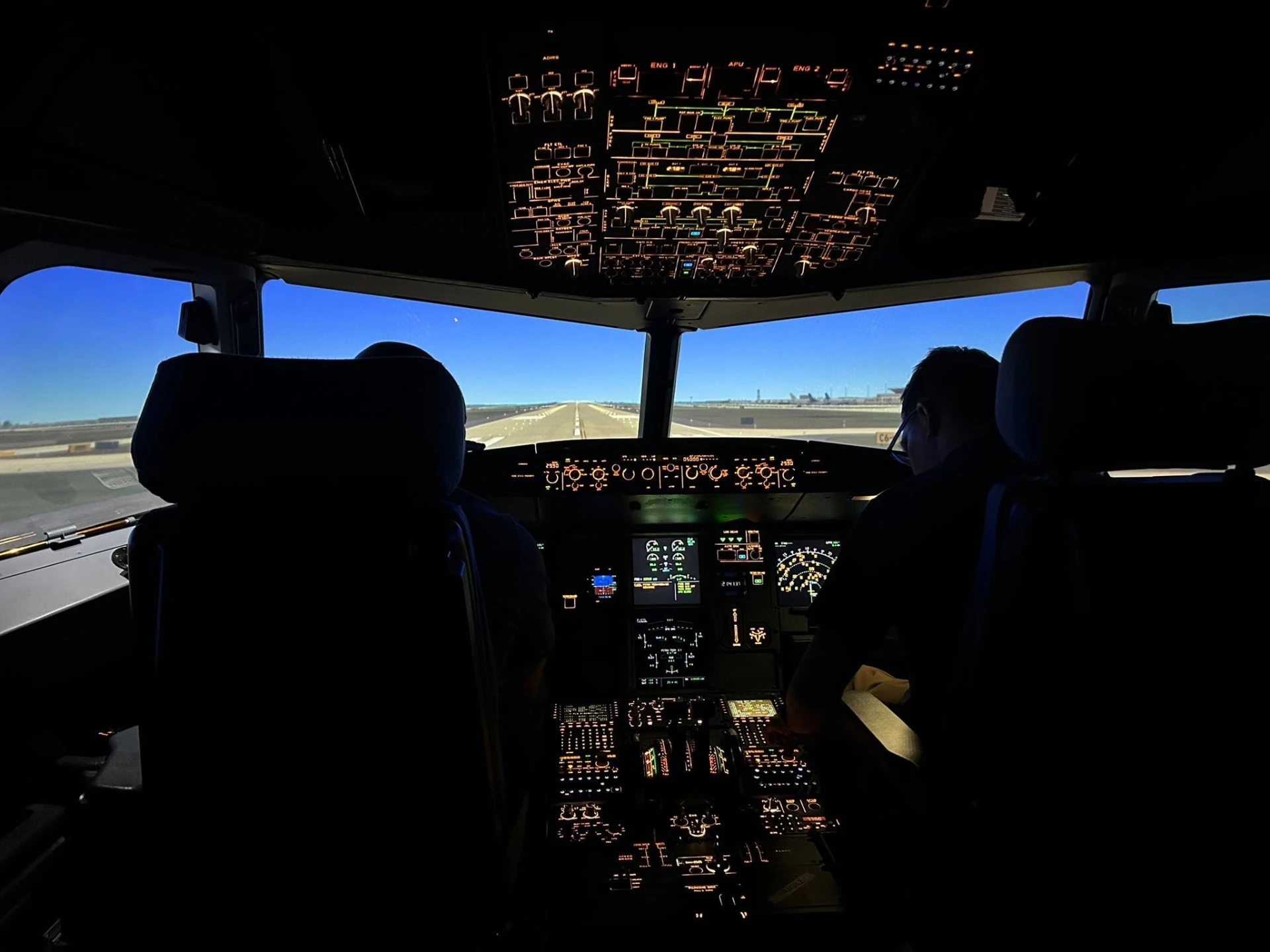 The simulator cockpit lit up with the runway in view