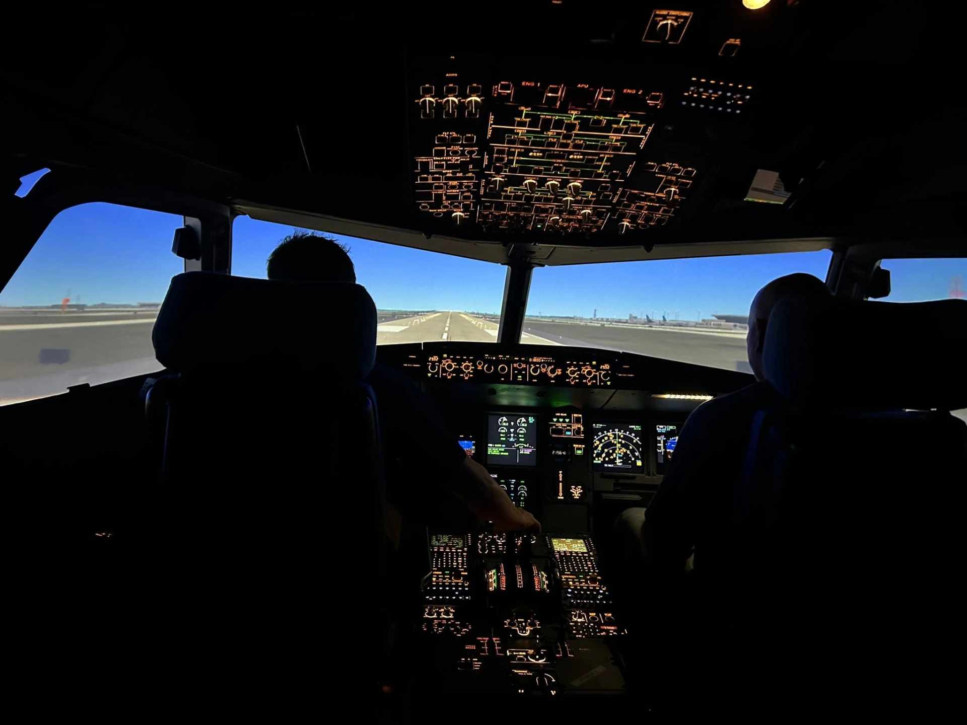 Two people in the simulator flight deck lined up on the runway